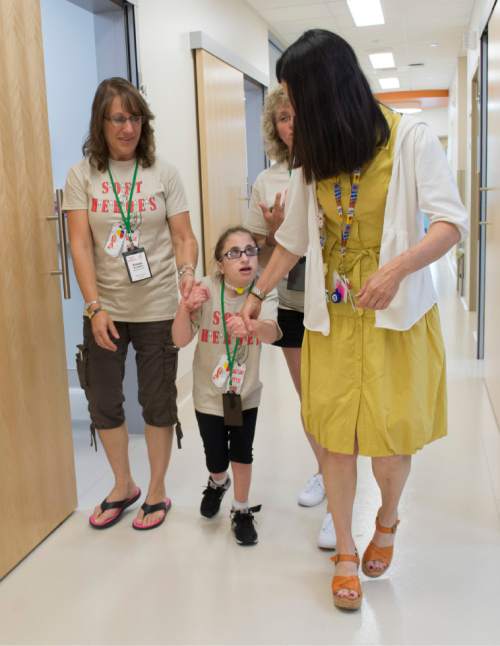 Rick Egan  |  The Salt Lake Tribune

Susan Aragona, Andover, Nj, (left) assists her 10-year-old daughter, Aniella Aragona, as they take a will with occupational therapist, Jackie Swan, during a special clinic for children with chromosomal disorders at Primary Children's Hospital, Friday, July 10, 2015. Trisomy is the presence of an extra chromosome.
