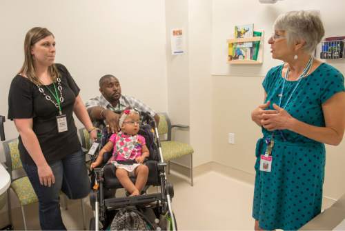 Rick Egan  |  The Salt Lake Tribune

Parents Kristen and Randal Thompson  Gainsville Fl, talk with Margaret Braae, speech and language specialist, about their daughter Payton Thompson, 19-months-old, during a special clinic for children with chromosomal disorders at Primary Children's Hospital, Friday, July 10, 2015. Trisomy is the presence of an extra chromosome.