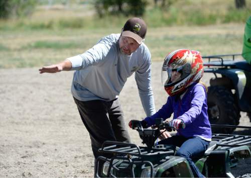 Scott Sommerdorf   |  The Salt Lake Tribune
Chris Haller with DNR gives instructions to eight year old Rylee Dolan during ATV instruction at the Weber County Fairgrounds. Primary Children's Hospital teamed up with Safe Kids and the Weber-Morgan Health Department to offer a special one-day course designed to keep kids safe while riding ATVs, Saturday, July 11, 2015.