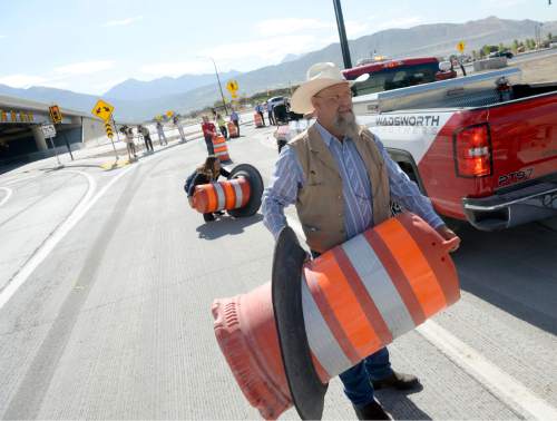 Al Hartmann  |  The Salt Lake Tribune
The freewaylike interchange at Bangerter Highway and Redwood Road is now open.  Bluffdale Councilman Ty Nielsen helped workers remove the last of the orange construction barrels on Thursday, July 16.
