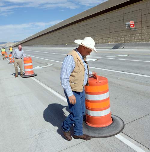 Al Hartmann  |  The Salt Lake Tribune
The freewaylike interchange at Bangerter Highway and Redwood Road is now open. Bluffdale Councilman Ty Nielsen, right, and Sen. Howard Stephenson, R-Draper, helped workers remove the last of the orange construction barrels on Thursday, July 16.