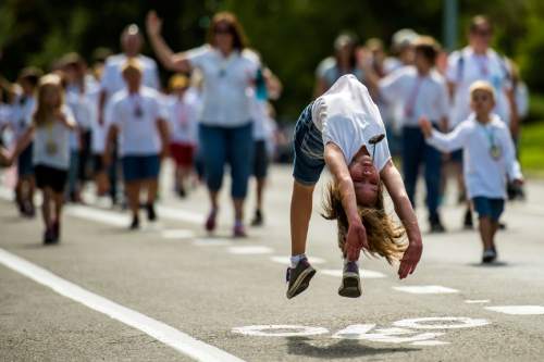 Chris Detrick  |  The Salt Lake Tribune
Mallory Zander, 10, does back flips in the annual Days of '47 Youth Parade through downtown Salt Lake City on Saturday.