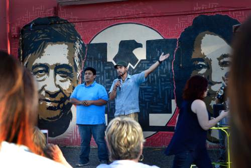 Scott Sommerdorf   |  The Salt Lake Tribune
Miguel Dominguez, left, owner of the Azteca De Oro Taqueria restaurant and artist Miguel Galaz speaks to the crowd during the vigil to save the mural of Cesar Chavez and Dolores Huerta on its north wall. The City of West Jordan is trying to get that restaurant to paint over or downsize the mural, saying it violates the city sign ordinance, Thursday, July 23, 2015.