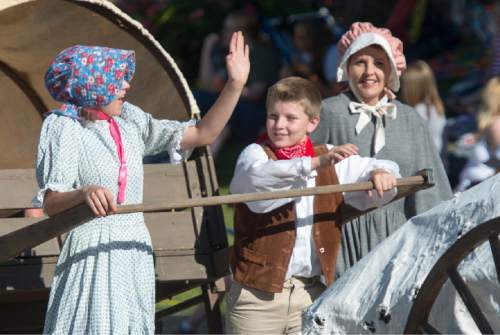 Rick Egan  |  The Salt Lake Tribune

L-R Anna Valentine, 15, Ethan Valentine, 12 and Linda Valentine, Layton, pull hand carts with the Sons of the Utah Pioneers entry, in the Days of '47 parade, Friday, July 24, 2015.