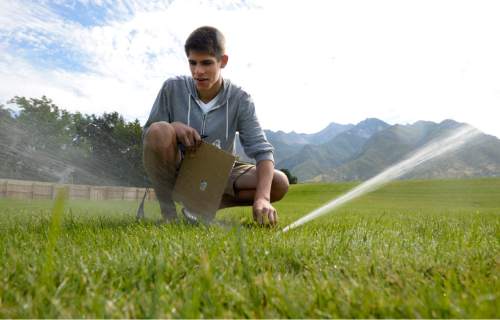 Al Hartmann  |  The Salt Lake Tribune
Water management intern Joseph Hawkins checks and adjusts sprinkler heads at Albion Middle School in 
Sandy Tuesday July 21.  The internships are payed through the Central Utah Water Conservency District to help make watering grounds at 15 schools in the Canyons School District more efficient and the grass healthier.