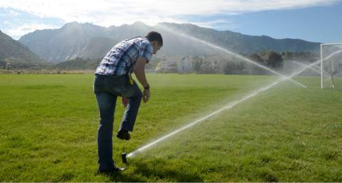 Al Hartmann  |  The Salt Lake Tribune
Water management intern Josh Perry checks and adjusts sprinkler heads at Albion Middle School in 
Sandy Tuesday July 21.  The internships are payed through the Central Utah Water Conservency District to help make watering grounds at 15 schools in the Canyons School District more efficient and the grass healthier.