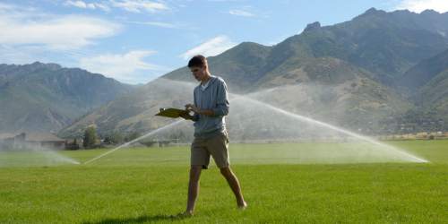 Al Hartmann  |  The Salt Lake Tribune
Water management intern Joseph Hawkins checks and adjusts sprinkler heads at Albion Middle School in 
Sandy Tuesday July 21.  The internships are payed through the Central Utah Water Conservency District to help make watering grounds at 15 schools in the Canyons School District more efficient and the grass healthier.