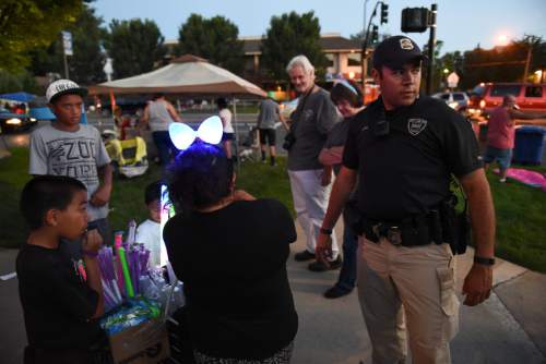 Francisco Kjolseth | The Salt Lake Tribune
Det. Mason Givens checks in with a vendor without a permit as he patrols the parade route the night before the Pioneer Day parade on Thursday night, July, 23, 2015.