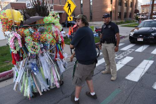 Francisco Kjolseth | The Salt Lake Tribune
Detective Mason Givens makes sure a vendor stays off the street in order to prevent any traffic accidents as he patrols the Pioneer Day parade route on Thursday night.