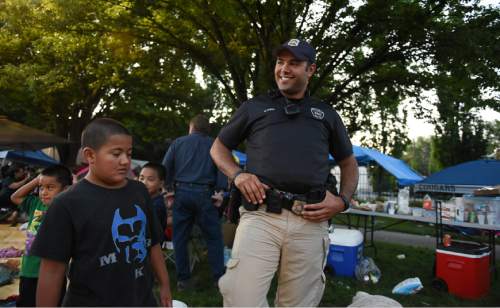 Francisco Kjolseth | The Salt Lake Tribune
Detective Mason Givens checks in with folks gathered along the Pioneer Day parade route as he works the graveyard shift through the night.