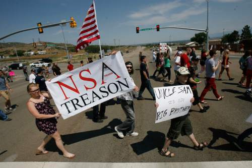 Francisco Kjolseth  |  The Salt Lake Tribune
Brandon Otterstron, center, of Clearfield joins others to protest the new NSA Data Center along Redwood road across from Camp Williams on the 4th of July.