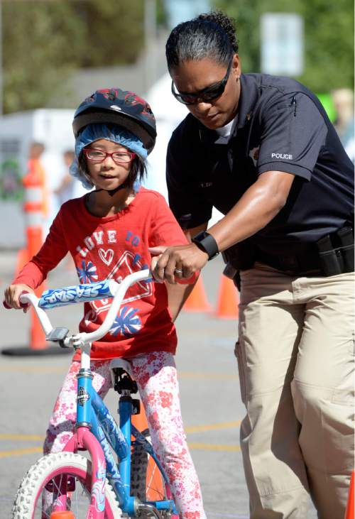Al Hartmann  |  The Salt Lake Tribune
In celebration of Playin' Safe, the Salt Lake City Police Department and SUBWAY® Restaurants partnered with the Boys & Girls Club of Great Salt Lake to host a safety event on Wednesday, July 28th.  Salt Lake City Police Sgt. Yvette Zayas helps Jacklyn Wei, 8, through the bicycle obstacle course to learn safety and the rules of the road.