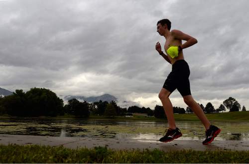 Al Hartmann  |  The Salt Lake Tribune
Cross country runners train in unusual cool rainy weather Monday August 3 at Sugarhouse Park.  Storm clouds hang heavy over the Wasatch Mountains to the east.