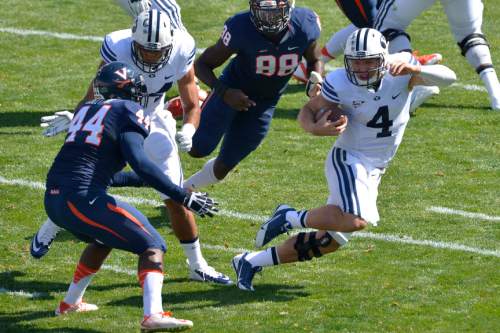 Chris Detrick  |  Tribune file photo
Brigham Young Cougars quarterback Taysom Hill (4) runs past Virginia Cavaliers linebacker Henry Coley (44) and Virginia Cavaliers linebacker Max Valles (88) during the game at LaVell Edwards Stadium Saturday September 20, 2014.