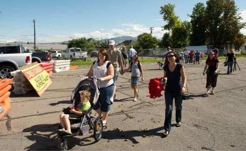 Rick Egan  |  The Salt Lake Tribune

South Salt Lake residents walk around the barricades that have closed traffic on Burton Avenue, as they march to State Street to demonstrate their opposition to the noise, inconvenience and increased traffic caused by the closure of Burton and Truman Avenues, Saturday, Aug. 8, 2015.