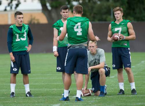 Leah Hogsten  |  The Salt Lake Tribune
Quarterback Taysom Hill talks with fellow backup quarterbacks l-r Koy Detmer, Jr., Tanner Mangum and Beau Hoge during Brigham Young University's first practice of fall football camp, August 8, 2015.