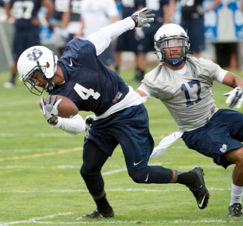 Steve Griffin  |  The Salt Lake Tribune

USU wide receiver Hunter Sharp spins away from corner back Deshone Hines during opening day of Utah State University football practice in Logan, Friday, August 7, 2015.  l