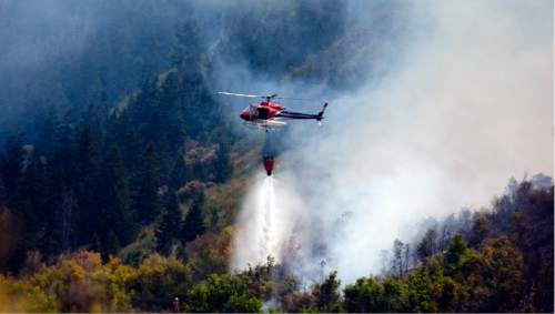 Kim Raff  |  Tribune file photo
Helicopters dump water on a wildfire off Highway 40 outside of Heber in Wasatch County in Aug. 2012. Wildfires this year have scorched far less acres than in previous years.