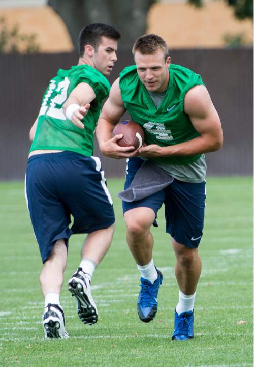 Leah Hogsten  |  The Salt Lake Tribune
Quarterbacks Tanner Mangum hands off to Taysom Hill at Brigham Young University's first practice of fall football camp, August 8, 2015.