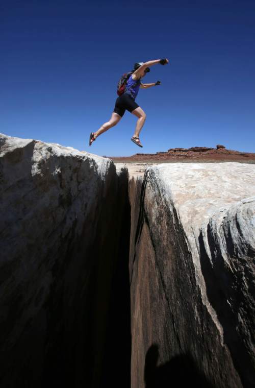 Francisco Kjolseth  |  The Salt Lake Tribune
Tammi Messersmith of Salt Lake City jumps over the seemingly bottomless Black Crack formation during a mountain biking trip on the White Rim Trail in Canyonlands National Park in May 2013.