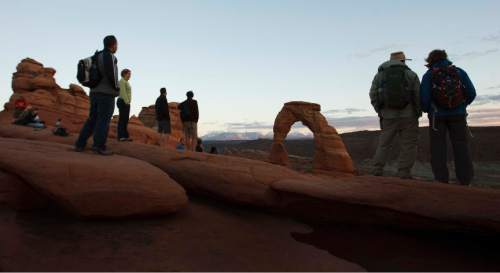 Leah Hogsten | The Salt Lake Tribune
Visitors mingled around Delicate Arch to watch the sunset in Arches National Park on October 11, 2014.