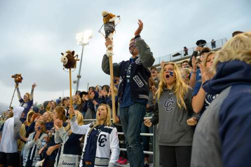 Leah Hogsten  |  The Salt Lake Tribune
Corner Canyon  seniors Greg Lamb (center, with stick pony) and Brooke Labrum (right) cheer on the Chargers. Friday night lights have begun for the 2014-2015 football season as Corner Canyon High School opened its 2014 football season against cross-town Draper rival Juan Diego High School, August 22, 2014.