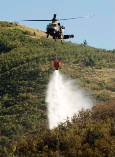 Rick Egan  |  The Salt Lake Tribune

Helicopters drop water on a wildfire near Mountain Dell, in Parley's Canyon, Saturday, August 15, 2015.
