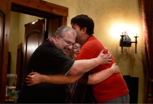 Scott Sommerdorf   |  The Salt Lake Tribune
Steve Afrin, left, and Doug Roberts, right, hug Pam Bradford as Roberts arrived at the "cuddle party" - a regular meet-up that happens in Utah, where strangers get together and cuddle in a nonsexual way, Friday, July, 31, 2015.