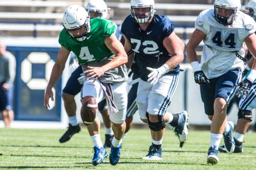 Chris Detrick  |  The Salt Lake Tribune
Brigham Young Cougars quarterback Taysom Hill (4) fumbles the ball during a scrimmage at LaVell Edwards Stadium Saturday August 15, 2015.