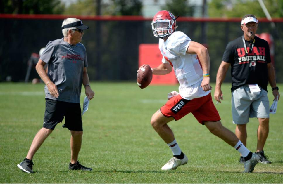 Al Hartmann  |  The Salt Lake Tribune
Ute quarterback Travis Wilson runs a play during practice Monday August 17.  Assistant head coach Dennis Erickson, left, and head coach Kyle Whittingham, right.