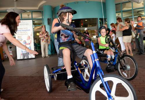 Al Hartmann  |  The Salt Lake Tribune
Bryce Herron, left, and Jacob Larsen try out their new adaptive bikes at Shriners Hospital for Children in Salt Lake City on Sunday, Aug. 23. They were two of the four children who received a bike, purchased by the Shriners with proceeds from their annual "Kruisers for Kids" car show fundraiser.
