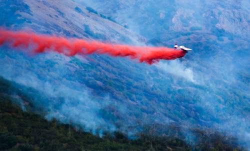 Rick Egan  |  The Salt Lake Tribune

A plane drops fire retardant on a fire in the mountains of Payson, Monday, August 24, 2015.