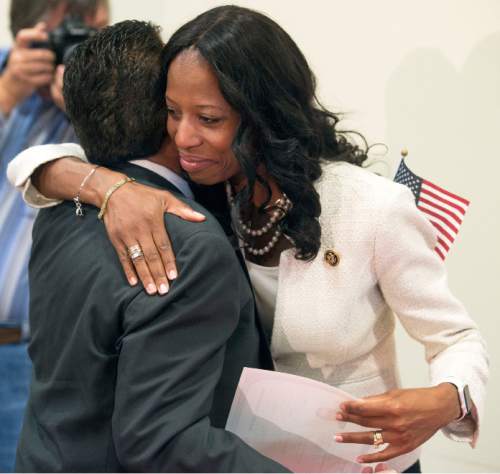 Steve Griffin  |  The Salt Lake Tribune

After 13 immigrants became American citizens during a  naturalization ceremony, Rep. Mia Love hugs new US citizen Alphonso DeLapaz as she gives him his certificate of citizenship at the South Jordan Library, Monday, August 24, 2015. Love also told the group of her family's immigration and lead them in the Pledge of Allegiance.