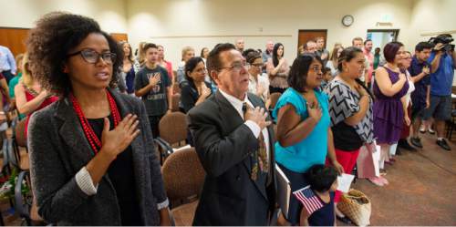 Steve Griffin  |  The Salt Lake Tribune

13 immigrants recite the  Pledge of Allegiance lead by Rep. Mia Love as they become American citizens during a  naturalization ceremony at the South Jordan Library, Monday, August 24, 2015.  Love also told them of her family's immigration story and awarded each citizen their certificate of citizenship.
