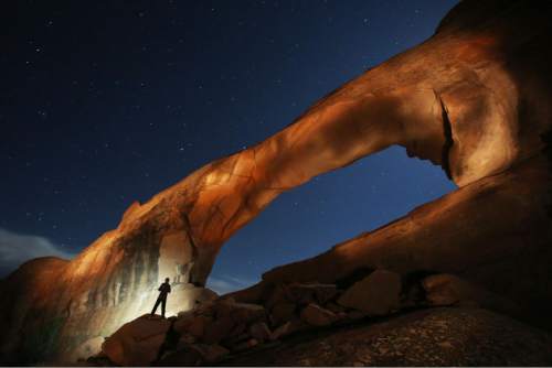 Francisco Kjolseth  |  The Salt Lake Tribune
Will Prettyman, 11, has fun playing the role of assistant as he lights up Skyline Arch next to the Arches National Park campground in late May.
