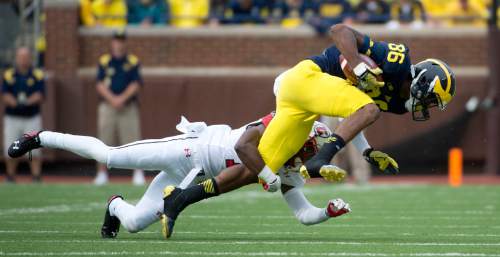 Jeremy Harmon  |  The Salt Lake Tribune

Michigan's Jehu Chesson (86) is tackled by Utah's Justin Thomas (12) as the Utes face the Wolverines in Ann Arbor, Saturday, Sept. 20, 2014.