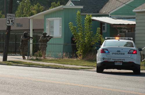 Alex Gallivan  |  Special to The Tribune
Unified Police SWAT officers get a view of the house, off camera to the right, where a suspect was heavily barricaded after a domestic dispute that turned into a standoff near 3300 South and 700 East, on Saturday.