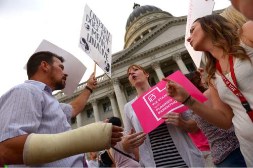 Leah Hogsten  |  The Salt Lake Tribune
Brandi Jensen, center, shares her opinions with an anti-Planned Parenthood protester at the rally. The Utah Capitol was covered in pink August 25, 2015 as Planned Parenthood Action Council of Utah held a community rally and proponents of the family- planning organization gathered. Governor Gary Herbert has said the money that would have gone to Planned Parenthood will be redirected to 26 health agencies in the state in 49 locations. Planned Parenthood estimates it will lose $75,000 of STD testing and more than $100,000 for educational programs.