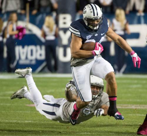 Rick Egan  |  The Salt Lake Tribune

Brigham Young Cougars running back Algernon Brown (24) outruns Nevada Wolf Pack linebacker Matthew Lyons (9) in football action, BYU vs The Nevada Wolf Pack at Lavell Edwards Stadium, Saturday, October18, 2014