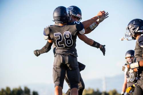 Chris Detrick  |  The Salt Lake Tribune
Summit Academy's Darrin Gethers (28) celebrates his touchdown with Summit Academy's Justin Miller (12) during the game at Summit Academy High School Thursday August 27, 2015.
