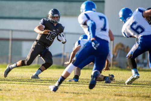 Chris Detrick  |  The Salt Lake Tribune
Summit Academy's Justin Miller (12) runs the ball during the game at Summit Academy High School Thursday August 27, 2015.