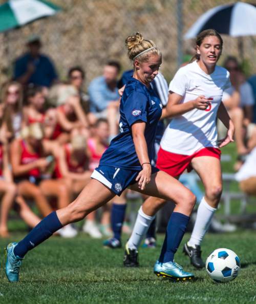 Chris Detrick  |  The Salt Lake Tribune
Woods Cross' Amanda Mangelson (21) runs past East's Jill Bennett (6) during the game at East High School Thursday August 27, 2015.