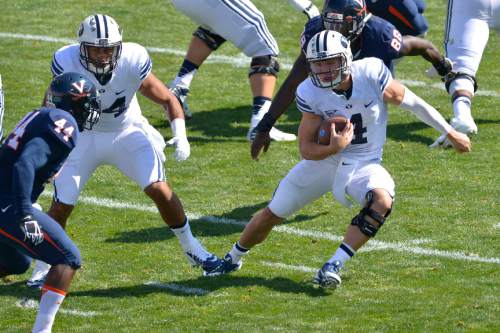 Chris Detrick  |  The Salt Lake Tribune
Brigham Young Cougars quarterback Taysom Hill (4) runs past Virginia Cavaliers linebacker Henry Coley (44) during the game at LaVell Edwards Stadium Saturday September 20, 2014.  Virginia is winning the game 16-13 at halftime.