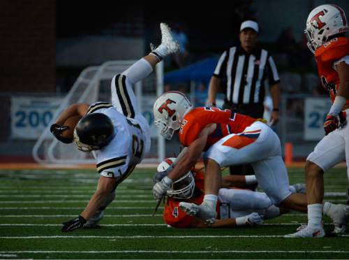 Scott Sommerdorf   |  The Salt Lake Tribune
Lone Peak RB Jackson McChesney is upended during first half play. Lone Peak led Timpview 14-7 at the half in Provo, Friday, August 28, 2015.