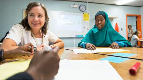 Steve Griffin  |  The Salt Lake Tribune

Katie Beerman, left, works with her students including Safeyo Osman, right,  with a reading assignment during her ninth grade class at the Utah International Charter School in Salt Lake City, Tuesday, September 1, 2015.
