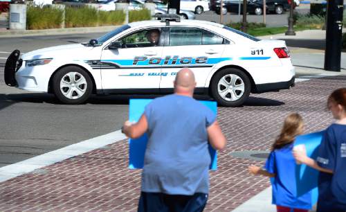 Scott Sommerdorf   |  The Salt Lake Tribune
Scott Powell holds a sign showing his support for West Valley City police as a police car rolls by and honks it's horn at a small rally to show support for police in West Valley City, Friday, September 4, 2015.