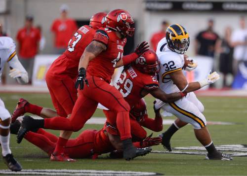 Francisco Kjolseth | The Salt Lake Tribune
Michigan Wolverines running back Ty Isaac (32) feels the Utah pressure in game action at Rice Eccles Stadium on Thursday, Sept. 3, 2015.