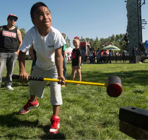 Rick Egan  |  The Salt Lake Tribune

Chris Bustamante, 9, holds a sledge hammer as he tries to ring the bell at the 15th Annual Labor Day Picnic, 
in Magna Copper Park,  Monday, September 7, 2015.