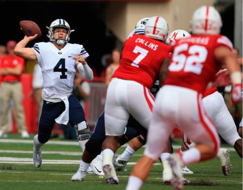 BYU quarterback Taysom Hill (4) throws under pressure from Nebraska defensive tackle Maliek Collins (7) and linebacker Josh Banderas (52) during the first half of an NCAA college football game in Lincoln, Neb., Saturday, Sept. 5, 2015. (AP Photo/Nati Harnik)