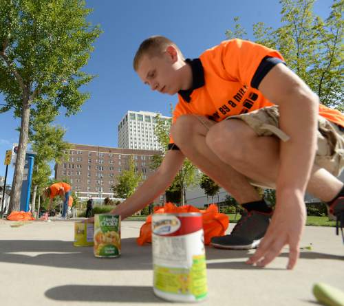 Al Hartmann  |  The Salt Lake Tribune
Hunter Podolan with Air Force ROTC vounteers for the Utah Food Bank in placing cans of food along State Street that eventually reached the Utah Capitol building Thursday September 3.   The Utah Food Bank kicked off National Hunger Action Month by asking Utahns to join forces in "Beating Hunger by a Mile."  Beginning at Washington Square in front of the City and County building in downtown Salt Lake, Utah Food Bank and their supporters created a mile-long line of food stretching all the way to the State Capitol steps.